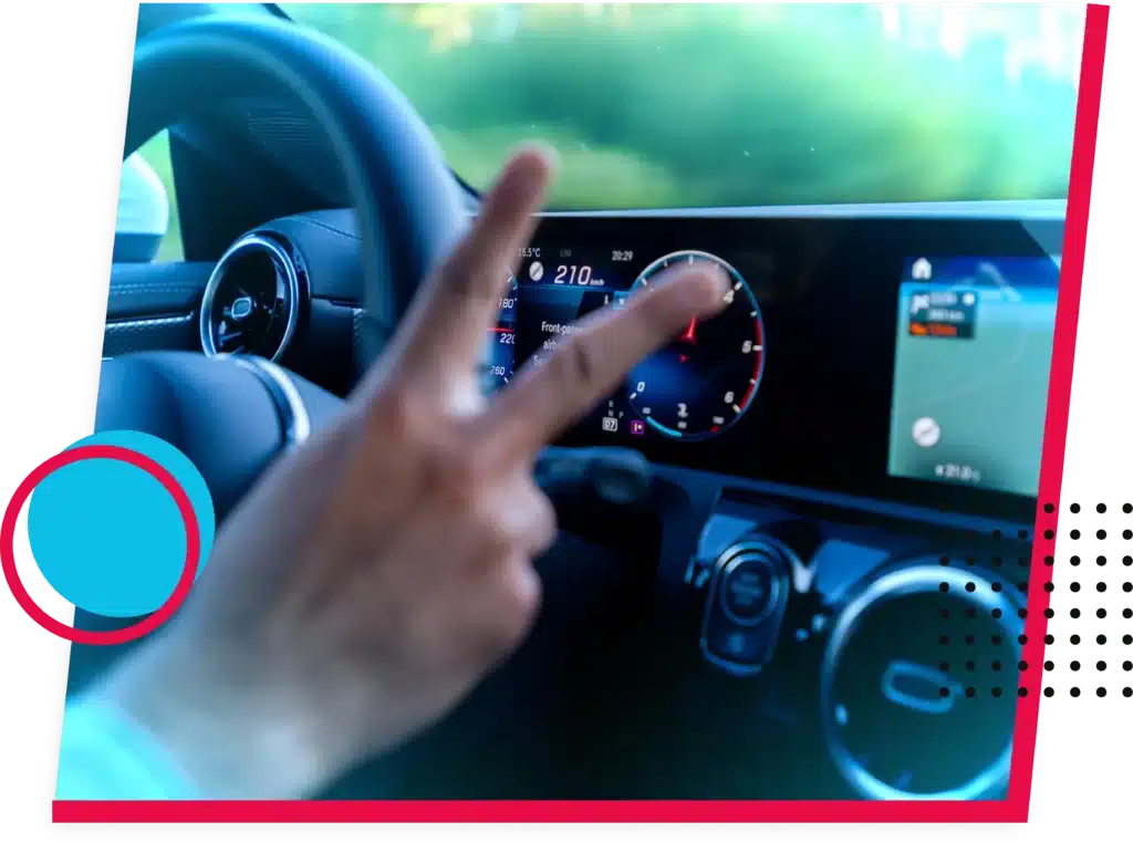 Hand wijst naar digitaal dashboard tijdens rijles in moderne auto Hand wijst naar digitaal dashboard tijdens rijles in moderne auto