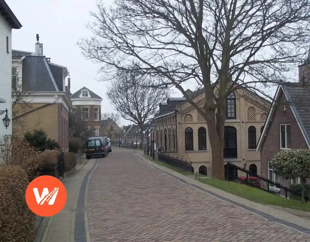 Straat met kinderkopjes in Capelle aan den IJssel met historische bakstenen gebouwen en rijschool logo Straat met kinderkopjes in Capelle aan den IJssel met historische bakstenen gebouwen en rijschool logo