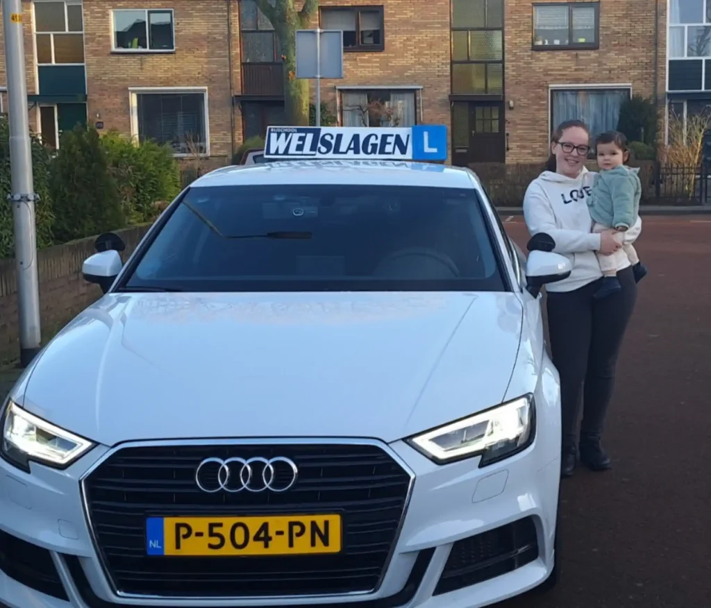 Geslaagde leerling met kind naast Rijschool Welslagen lesauto in Rotterdam