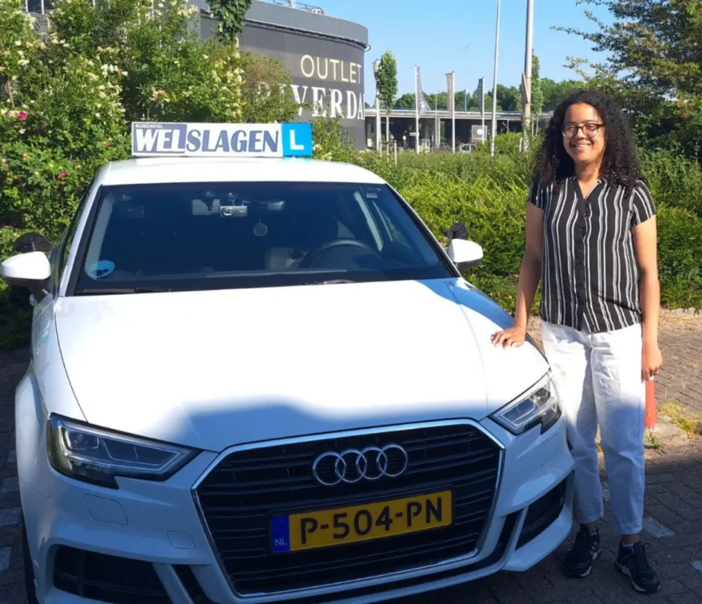 Geslaagde leerling naast Rijschool Welslagen lesauto met L-bord in Rotterdam