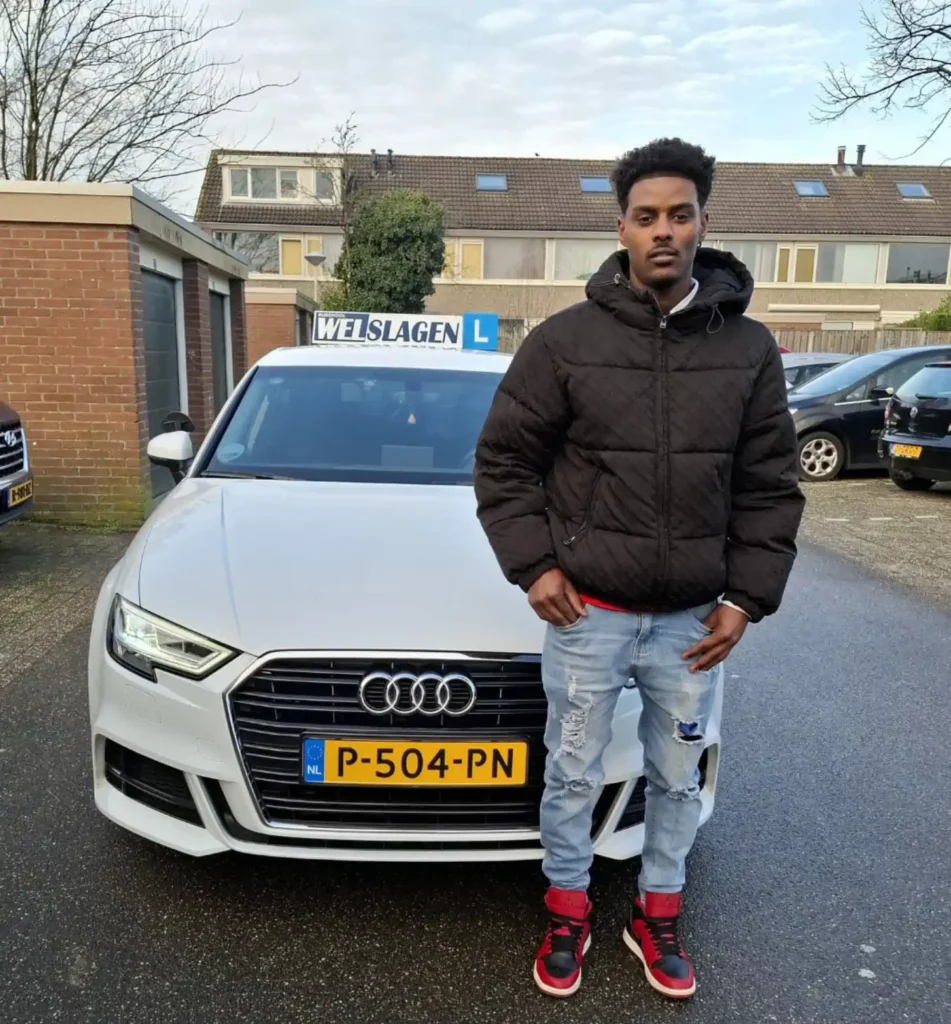 Geslaagde leerling poseert trots naast lesauto van Rijschool Welslagen in Rotterdam
