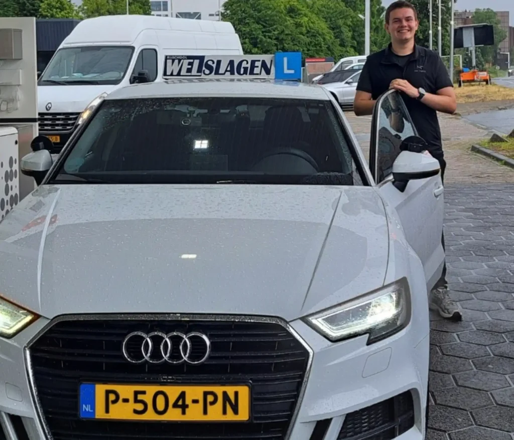 Geslaagde leerling staat bij witte Audi lesauto van Rijschool Welslagen na het behalen van rijbewijs