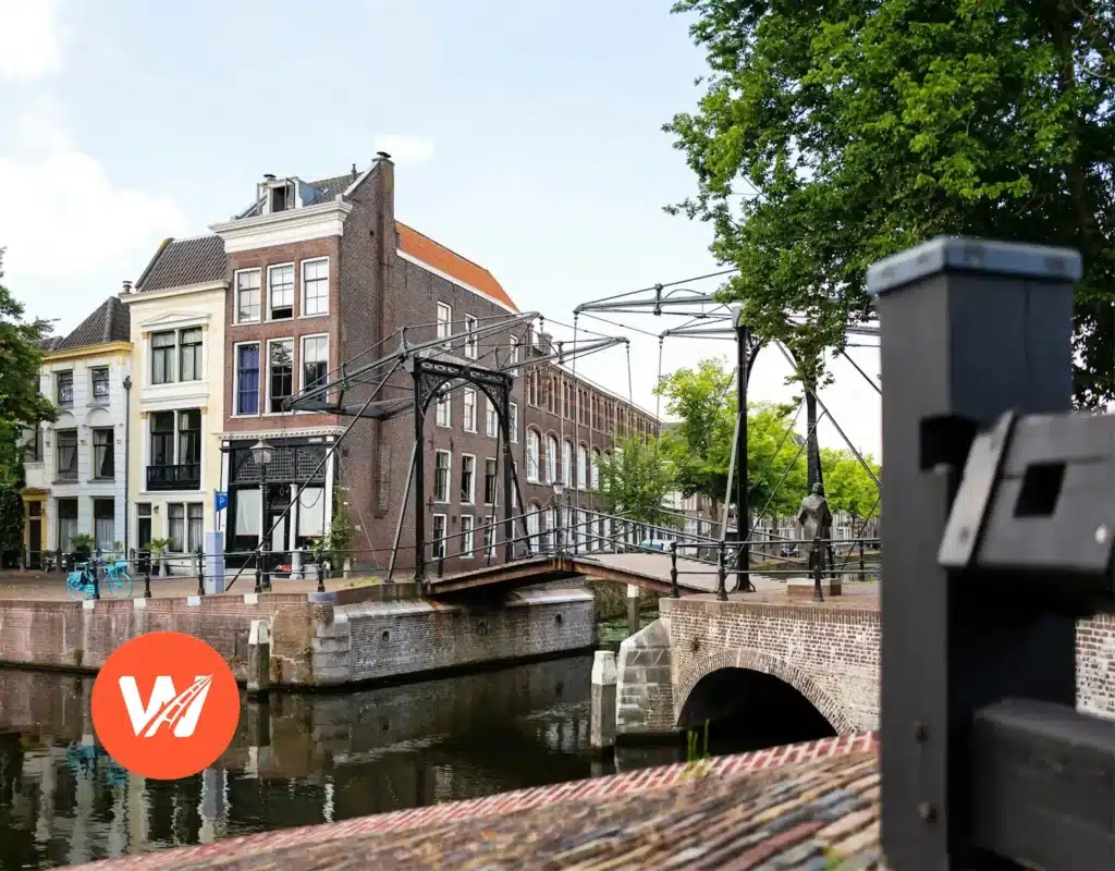 Historische ophaalbrug over kanaal in Schiedam met traditionele Nederlandse architectuur en groene bomen Historische ophaalbrug over kanaal in Schiedam met traditionele Nederlandse architectuur en groene bomen