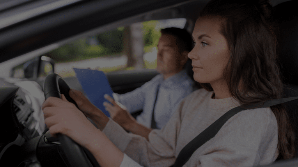 Vrouwelijke rijleerling achter het stuur tijdens rijles met instructeur die notities maakt bij Rijschool Welslagen Rotterdam