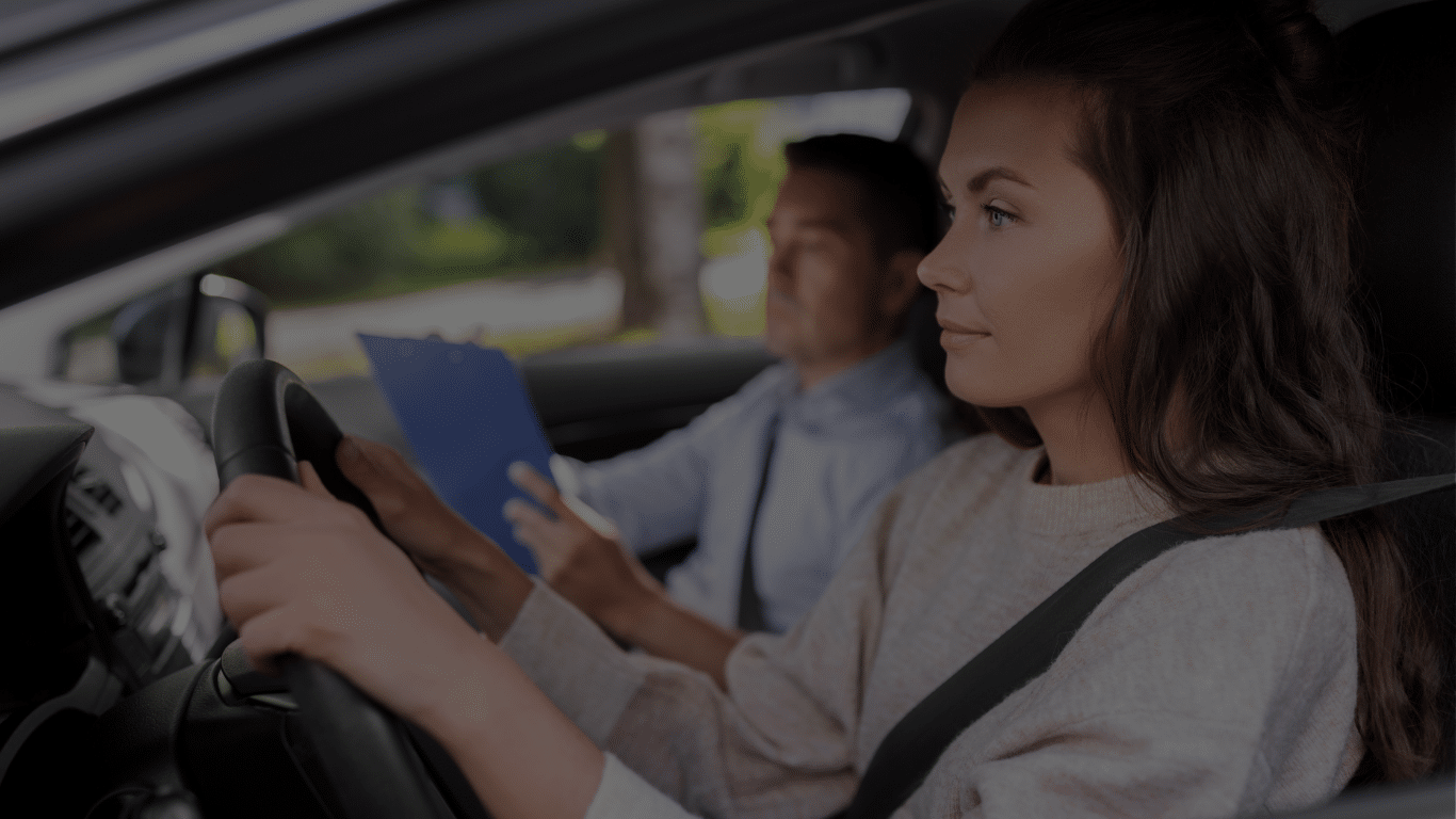 Vrouwelijke rijleerling achter het stuur tijdens rijles met instructeur die notities maakt bij Rijschool Welslagen Rotterdam